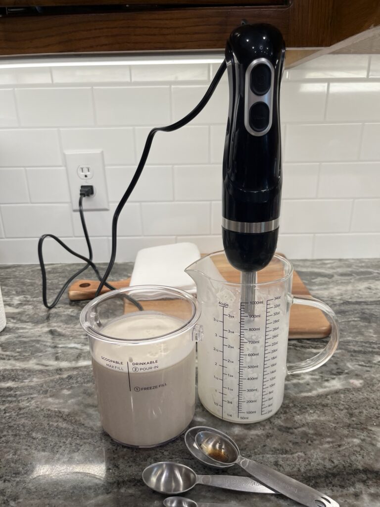 Mixing Classic Vanilla Bean ice cream base with an immersion blender for the Ninja CREAMi Deluxe